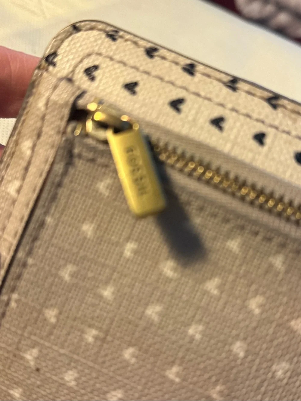 Fossil Putty and white exterior with black hearts; with brown lining Wristlet